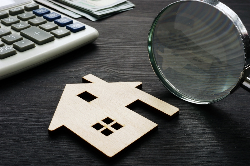 paper house and magnifying glass