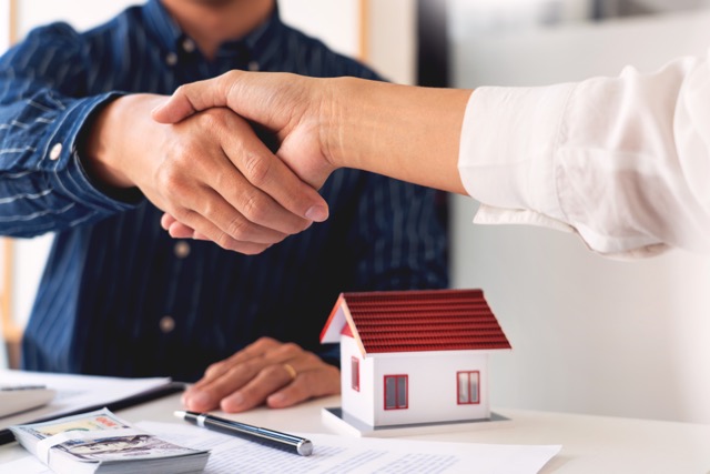 A real estate professional shaking hands with a home seller
